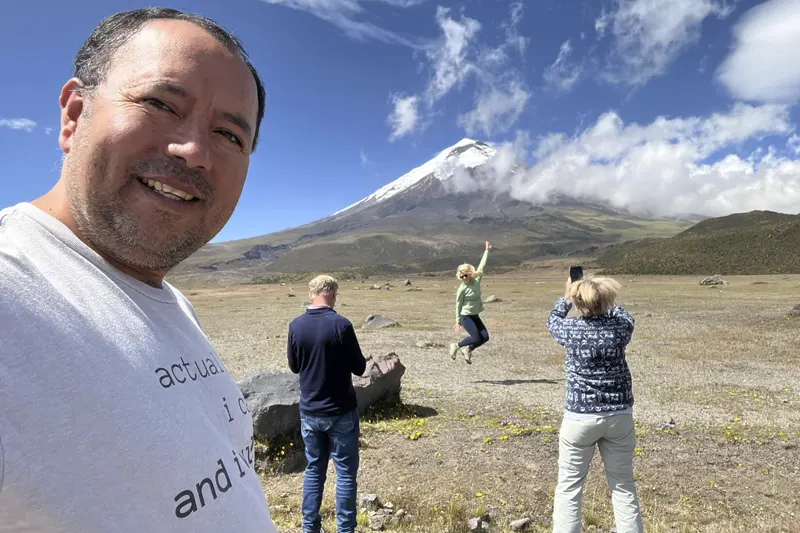 Marco Herrera with travelers enjoying the view and taking photos at Cotopaxi Volcano, Ecuador