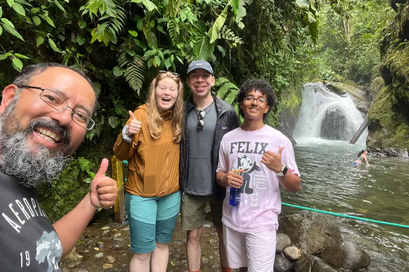 Marco Herrera with travelers at a waterfall in Mindo cloud forest, Ecuador